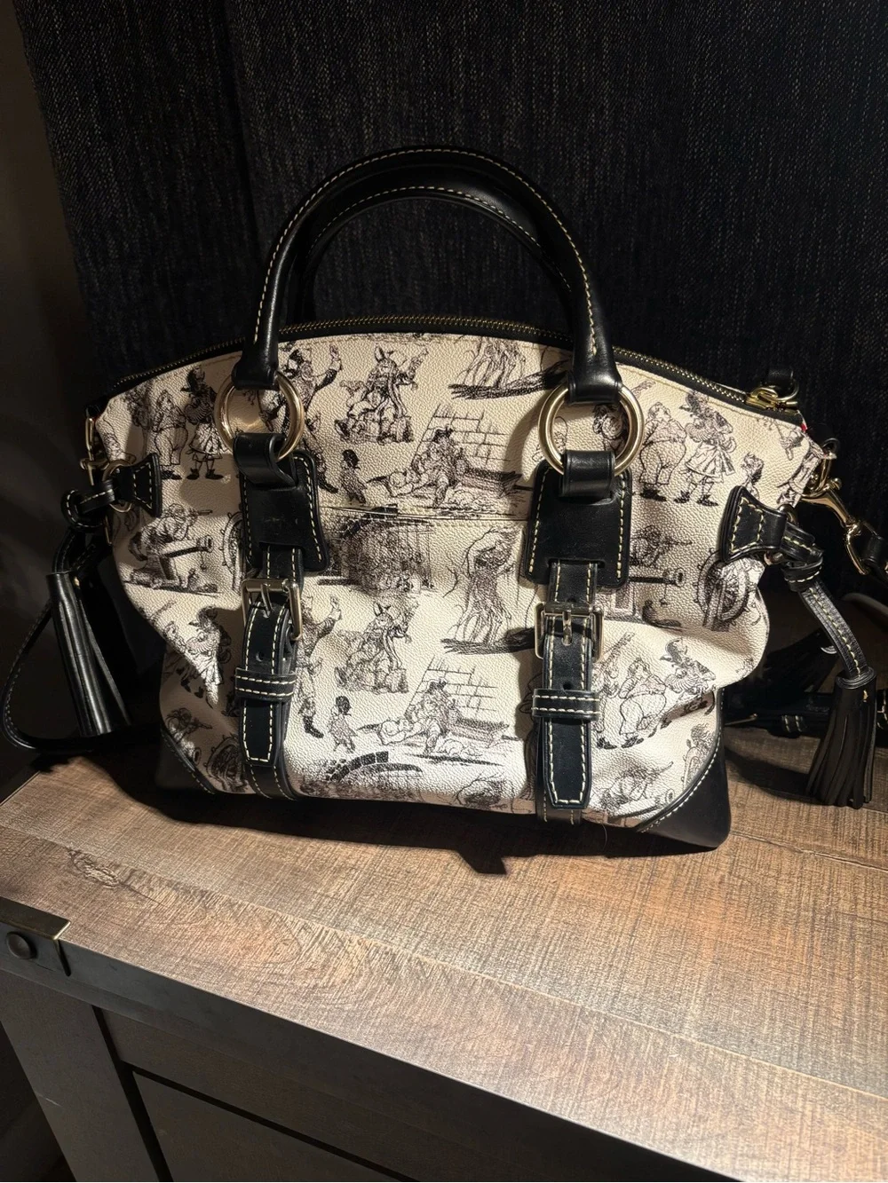 Dooney & Bourke Black and Cream Graphic Satchel with shoulder strap included.